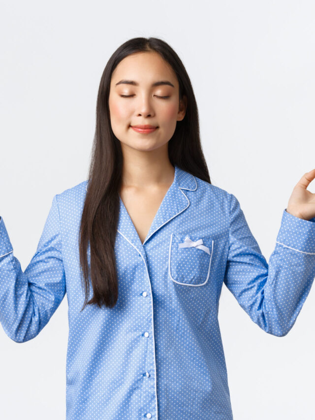 Calm and happy smiling asian girl in blue pajamas close eyes, meditating before sleep or in morning, looking relieved and peaceful, practice yoga meditation over white background