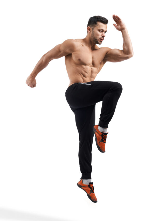 Shirtless bodybuilder jumping in place.